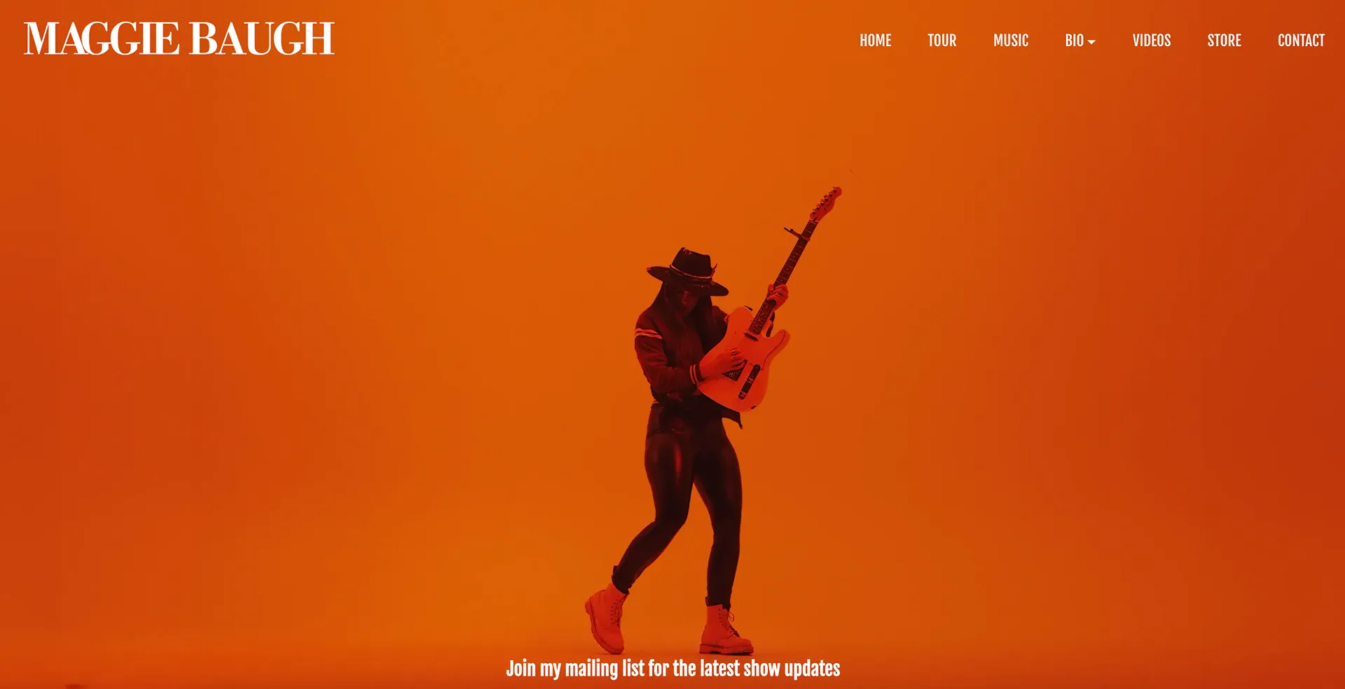 Maggie Baugh's homepage: a full-width orange photo of her playing guitar, with Tour, Music, Videos, Store and Contact in the navigation