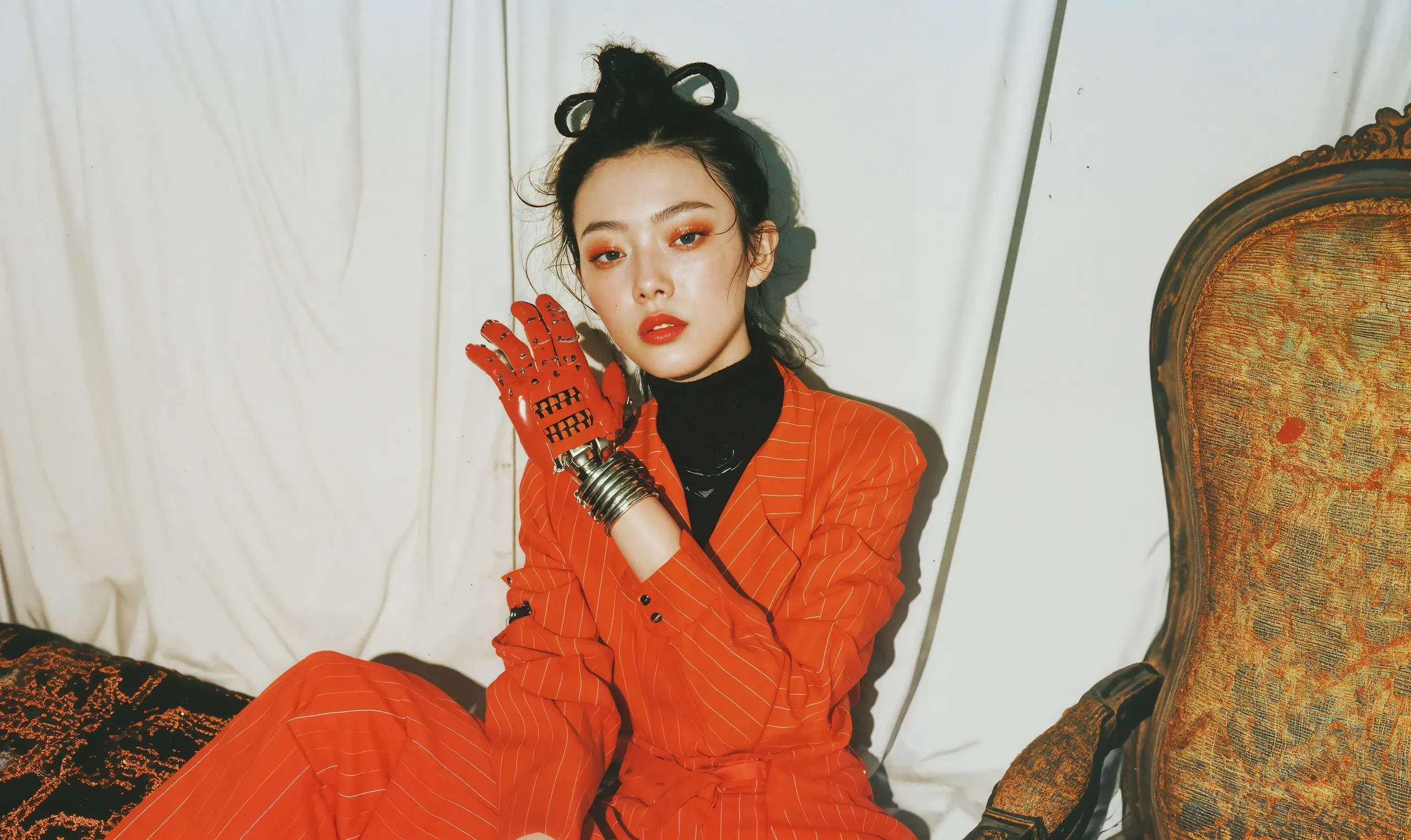AI-generated portrait of a woman in an orange suit and red gloves seated beside a gilded armchair in a white room