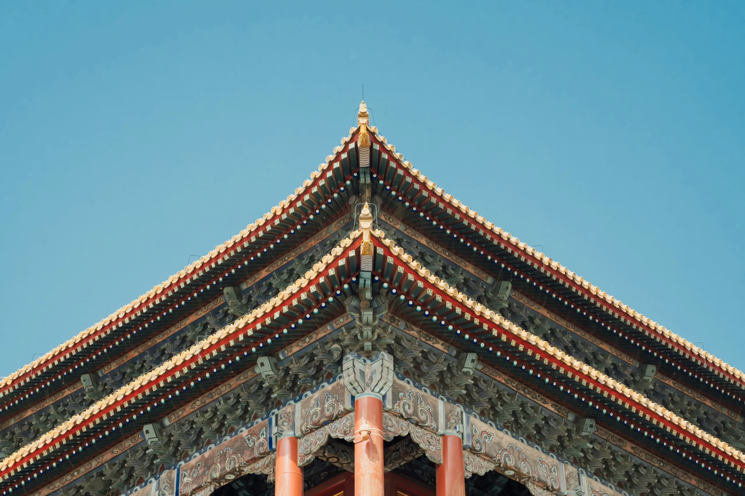 The painted eaves of a traditional Chinese roof against a blue sky