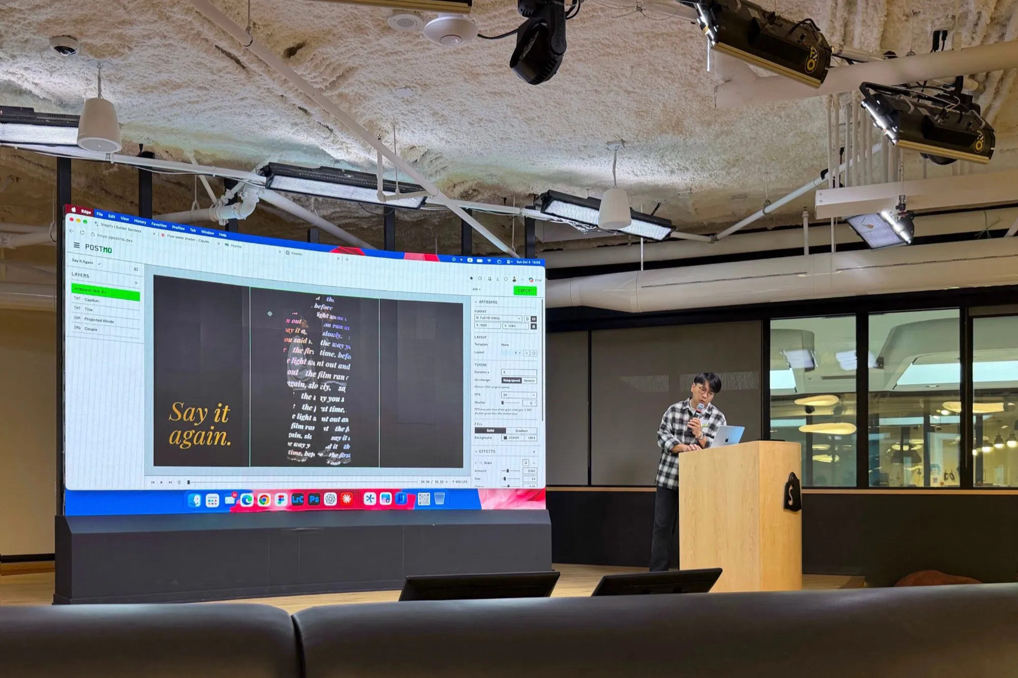 Me at the lectern at Shopify Builder Sundays in Ottawa, presenting Postmo; the LED wall shows a motion poster that reads Say it again.